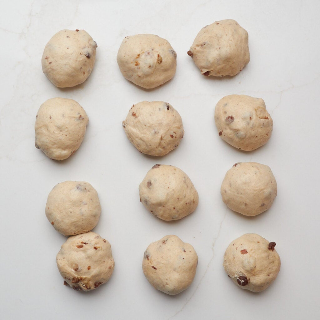 Cinnamon Raisin Sourdough Bagel dough divided into 12 equal pieces.