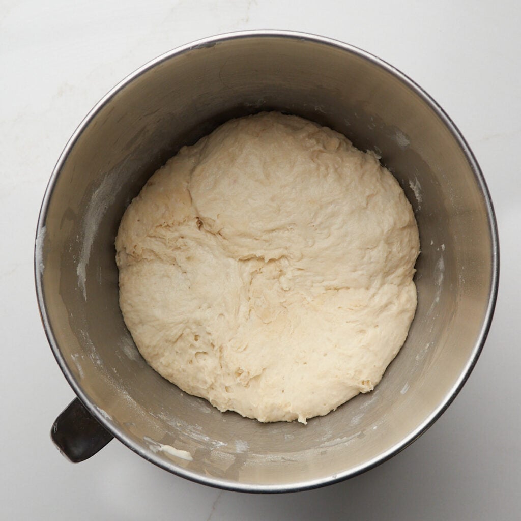 Sourdough English Muffin dough in a metal mixing bowl after the first rise.