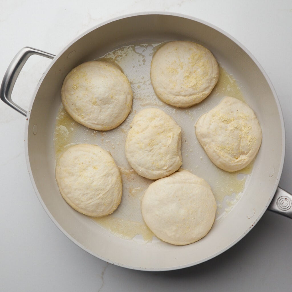 Sourdough English Muffin dough in a skillet with butter.